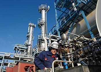 Man on an oil rig looking at pipes